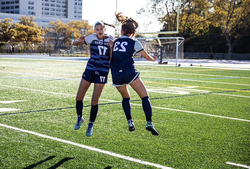 Poly Girls Soccer athletes jumping into the air